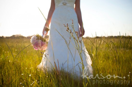 Stunning bridal portrait: Bride in white dress with bouquet in meadow