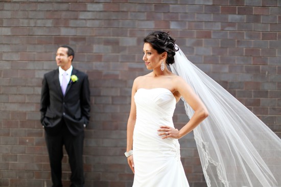 Romantic bride and groom pose beautifully at a brick wall wedding.