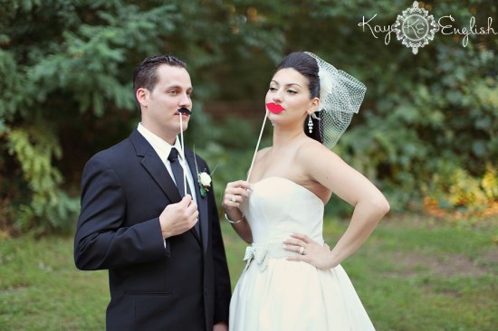 Funny bride and groom with mustache props at a wedding