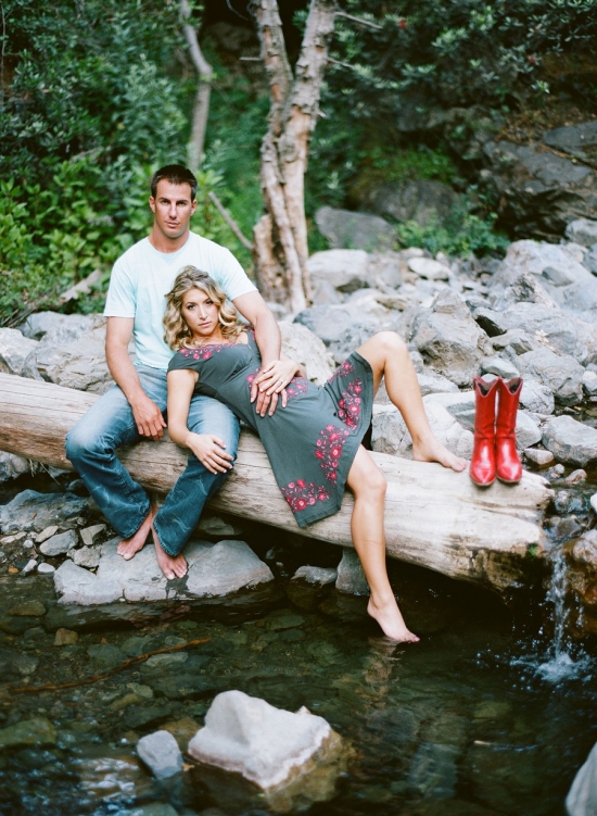 Couple relaxes by creek in red boots scenic outdoor setting