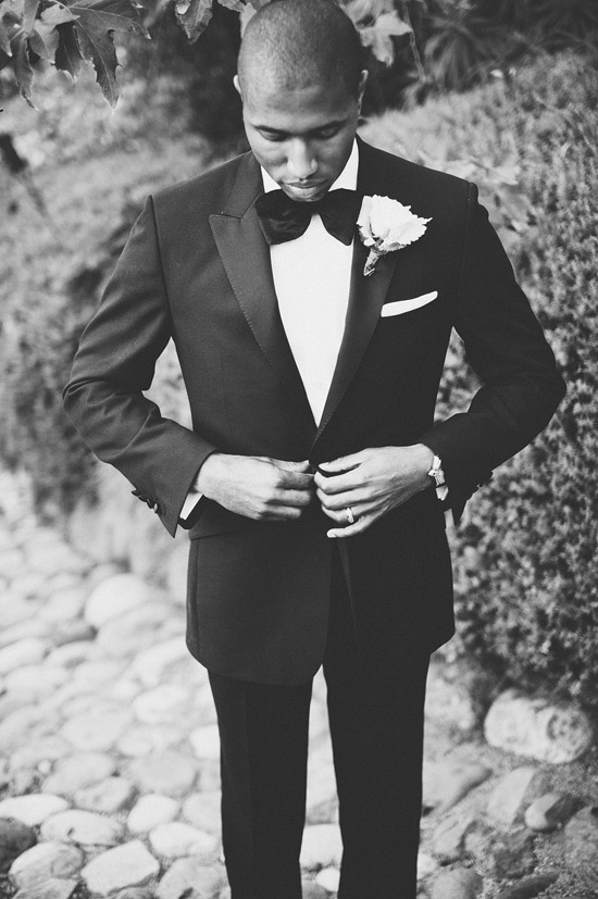 Groom in Classic Tux Adjusts Jacket Before Wedding Ceremony