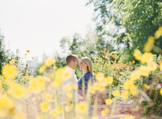 Romantic engagement photos in a sunny field of yellow flowers
