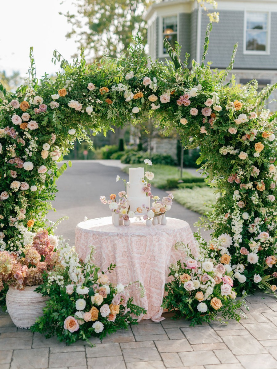 Peach garden wedding with a floral draped tented reception