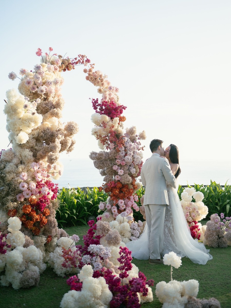 Wedding under a Bali sky filled with clouds of peach and pink florals